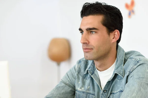 Goed uitziende man dragen denim shirt zitten in een coffee bar — Stockfoto