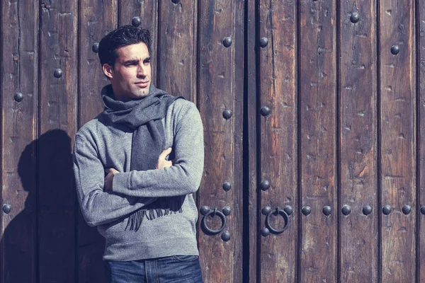 Hombre guapo con ropa de invierno en fondo de madera . —  Fotos de Stock