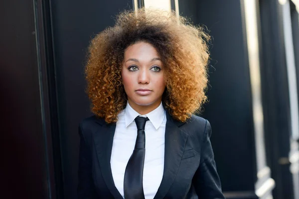 Schwarze Geschäftsfrau mit Anzug und Krawatte im urbanen Hintergrund — Stockfoto