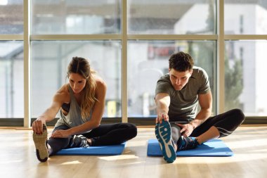 İki spor salonu bacaklarını açıp streching kişi.