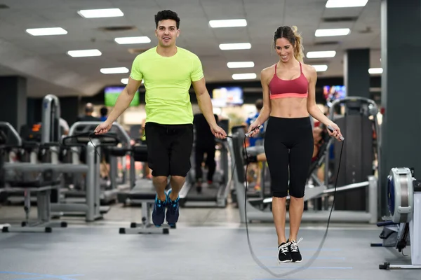 Entrenamiento de hombre y mujer con cuerda de salto en gimnasio crossfit —  Fotos de Stock