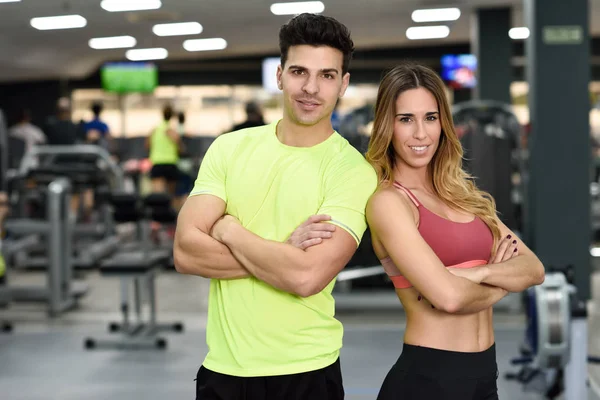 Άνδρας και γυναίκα προσωπικοί γυμναστές στο γυμναστήριο. — Φωτογραφία Αρχείου
