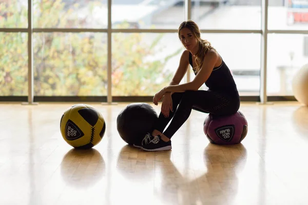 Vrouw zitten met fitballs in de sportschool. — Stockfoto