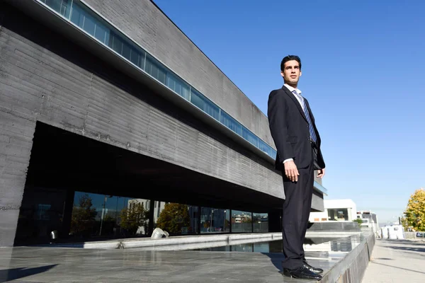 Young businessman wearing blue suit and tie in urban background — Stock Photo, Image