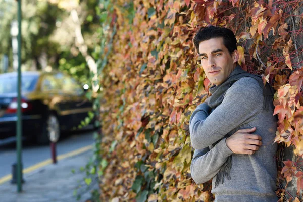 Schöner Mann in Winterkleidung im Holzhintergrund. — Stockfoto