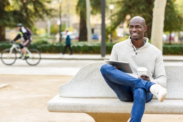 Joven negro con tableta y tomar café — Foto de Stock