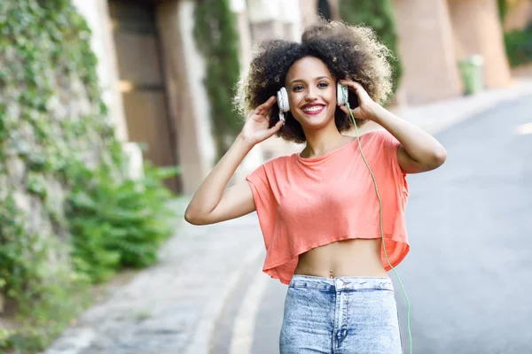 Ung svart kvinna med afro frisyr leende i stadsparken — Stockfoto