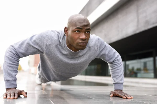 Fitness schwarzer Mann übt Liegestütze im urbanen Hintergrund — Stockfoto