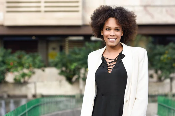 Joven mujer negra con peinado afro sonriendo en el fondo urbano —  Fotos de Stock