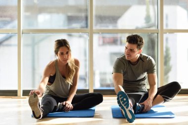 İki spor salonu bacaklarını açıp streching kişi.