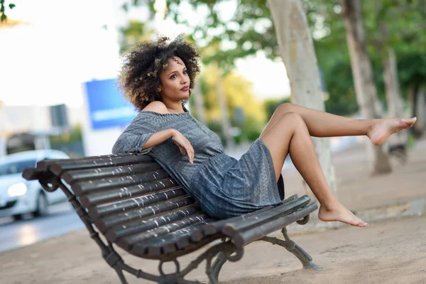 Joven mujer negra con peinado afro sonriendo en el fondo urbano —  Fotos de Stock