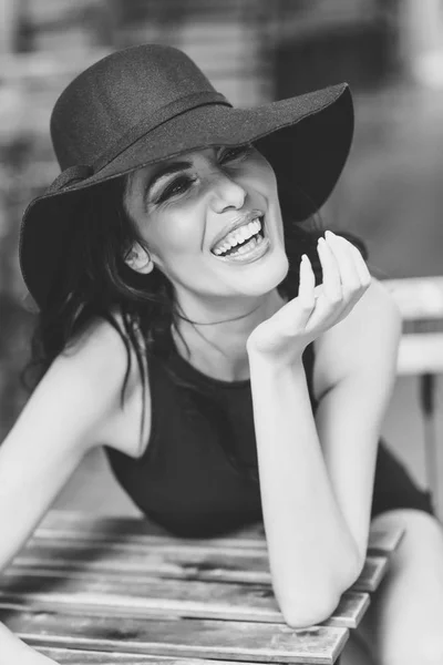 Woman wearing black seductive dress sitting in a outdoors bar — Stock Photo, Image