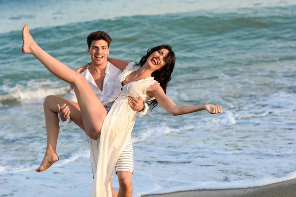 Jovem casal feliz andando em uma bela praia — Fotografia de Stock