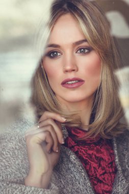 Kayıp gözleri penceresinde düşünceli genç sarışın kadınla