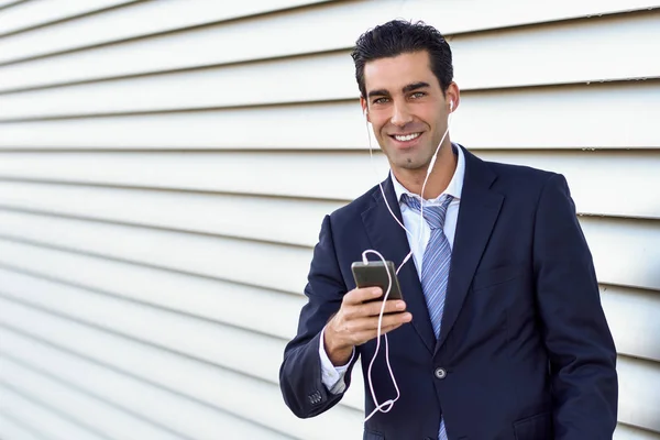 Affärsman som bär blå kostym och slips med en smartphone. — Stockfoto
