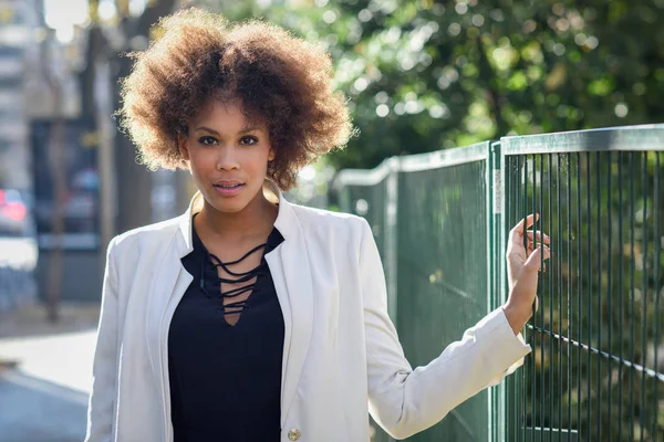 Joven mujer negra con peinado afro de pie en el fondo urbano — Foto de Stock