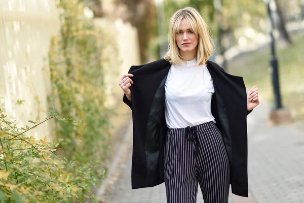 Beautiful young blonde woman in urban background — Stock Photo, Image