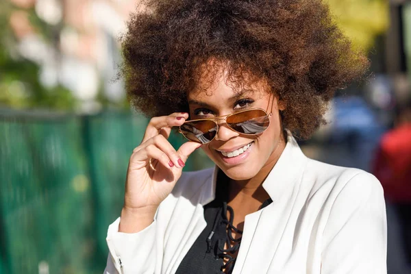 Ung svart kvinna med afro frisyr med aviator solglasögon — Stockfoto