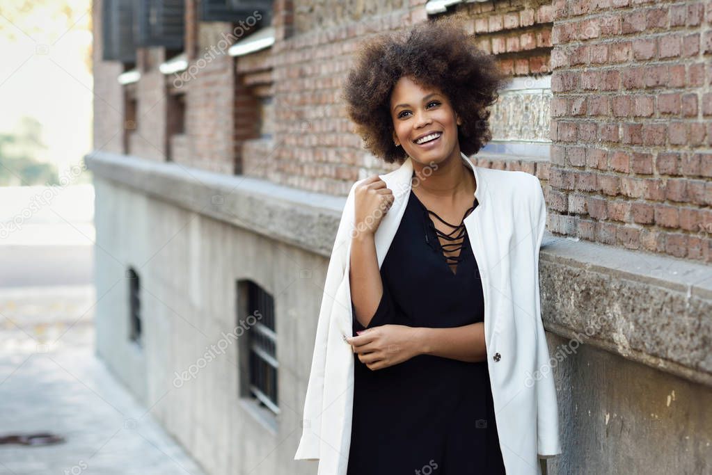 Young black woman with afro hairstyle standing in urban backgrou