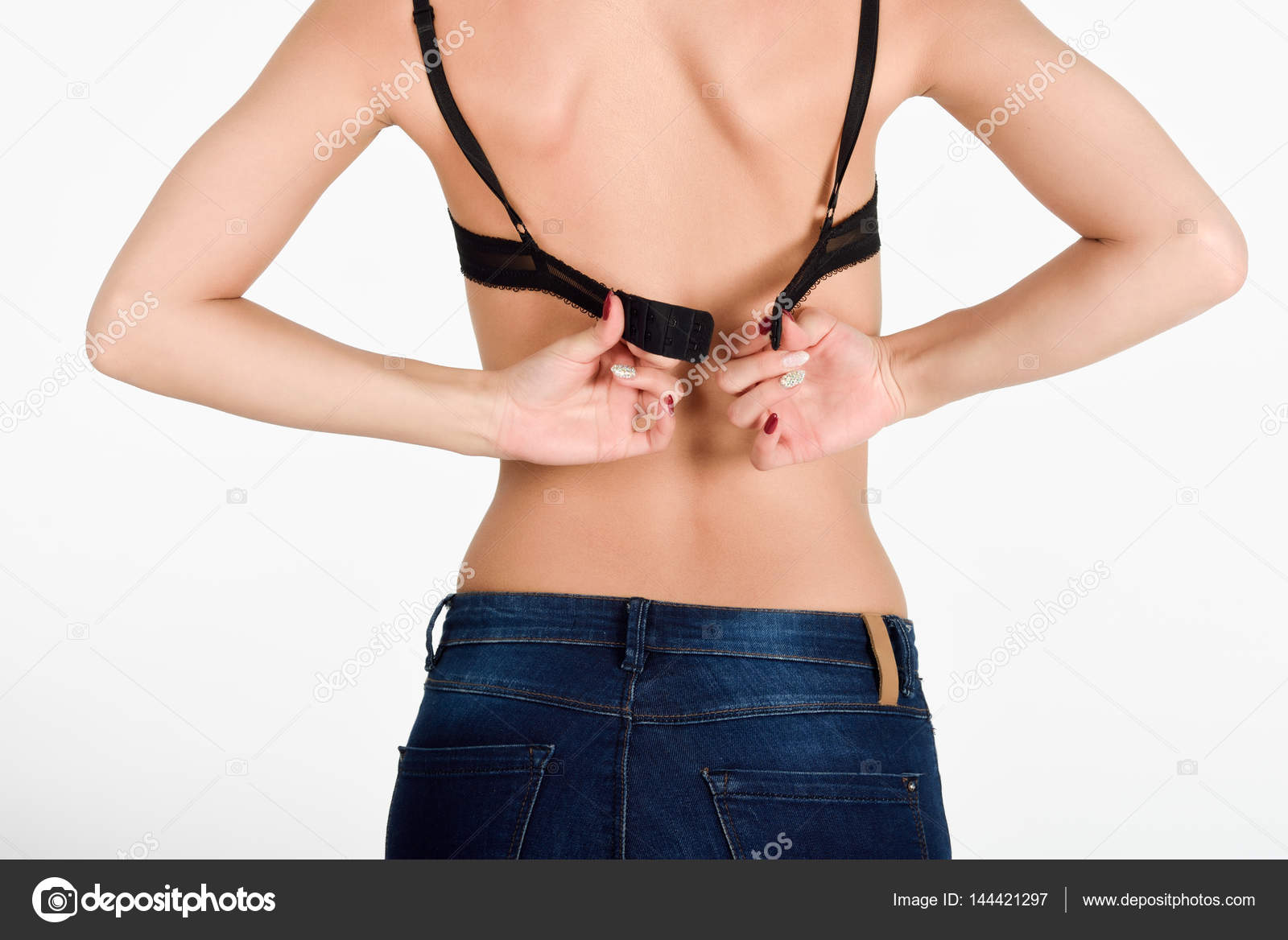 Woman unhooking the clasp of her black bra Stock Photo by