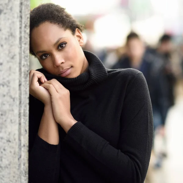 Joven mujer negra con peinado afro de pie en el fondo urbano — Foto de Stock