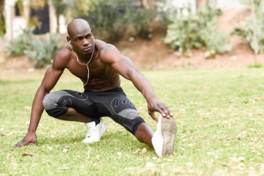 Kentsel arka planda çalıştırmadan önce germe yapan siyah erkek