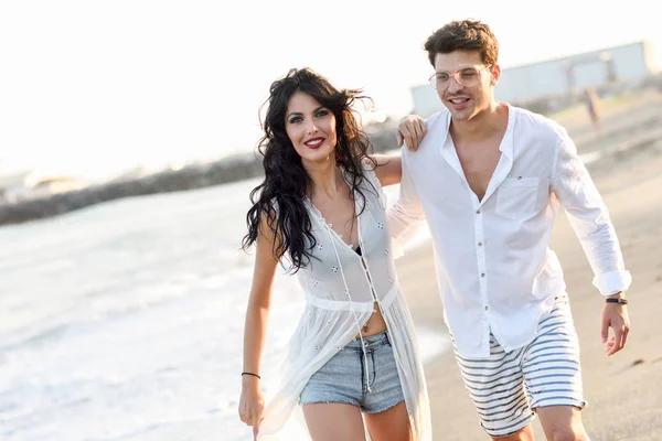 Giovane coppia felice a piedi in una bella spiaggia — Foto Stock