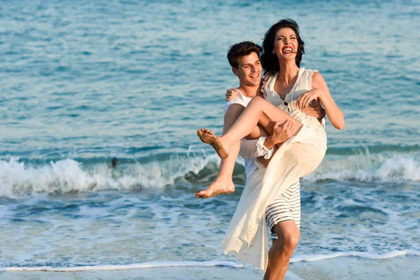 Jovem casal feliz andando em uma bela praia — Fotografia de Stock