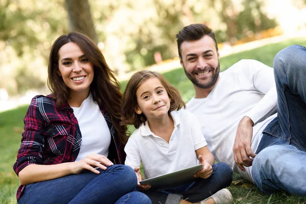 Happy family in a urban park playing with tablet computer — Stock Photo, Image