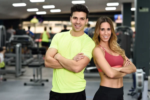 Homem e mulher personal trainers no ginásio . — Fotografia de Stock