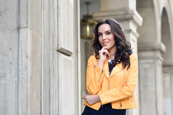 Young brunette woman standing in urban background. — Stock Photo, Image