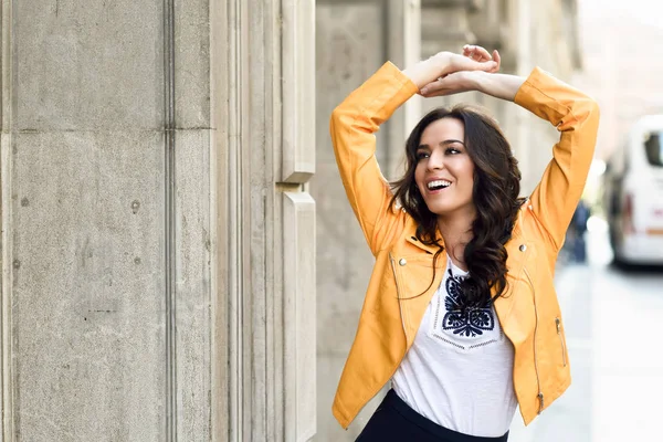 Jovem morena sorrindo em fundo urbano . — Fotografia de Stock