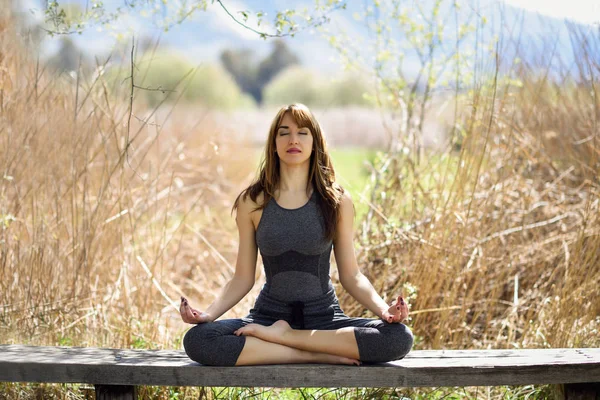 Wanita cantik muda melakukan yoga di alam — Stok Foto