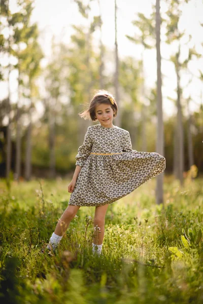 Маленькая девочка в поле природы в красивом платье — стоковое фото