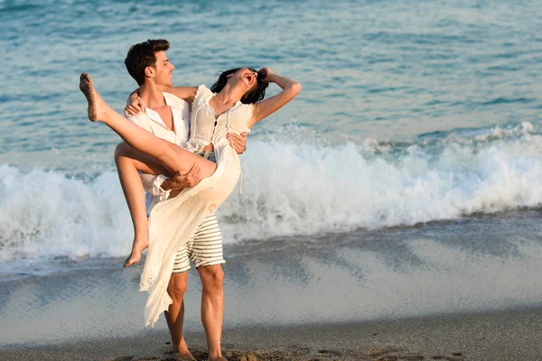 Jovem casal feliz andando em uma bela praia — Fotografia de Stock