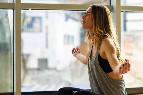 Spor salonunda lotus pozisyonda meditasyon genç güzel kadın — Stok fotoğraf