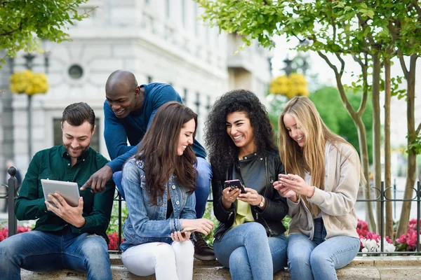 Wieloetnicznego młodych ludzi przy użyciu smartfonów i tabletów — Zdjęcie stockowe