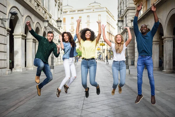 Grupo de amigos saltando juntos al aire libre — Foto de Stock