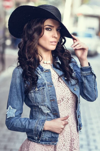 Young brunette woman standing in urban background. — Stock Photo, Image
