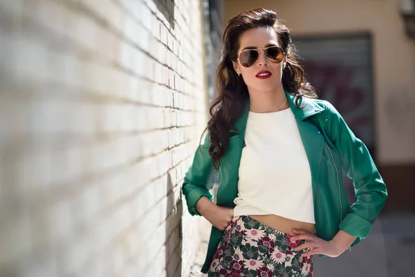 Mujer morena joven con gafas de sol en el fondo urbano —  Fotos de Stock