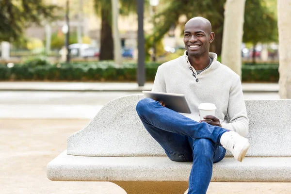 Schwarzer junger Mann mit Tablet-Computer und Kaffee zum Mitnehmen — Stockfoto