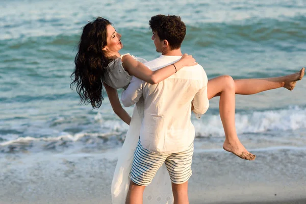Junges glückliches Paar spaziert an einem schönen Strand — Stockfoto