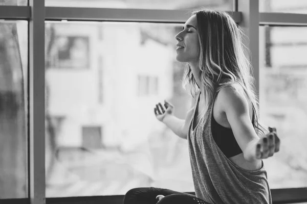 Молодая красивая женщина медитирует в позе лотоса в спортзале — стоковое фото