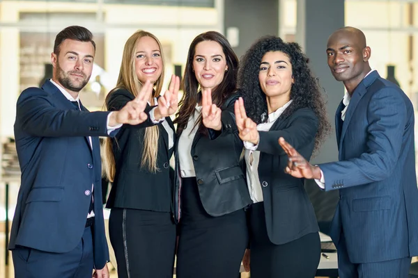 Group of businesspeople with thumbs up gesture in modern office. — Stock Photo, Image