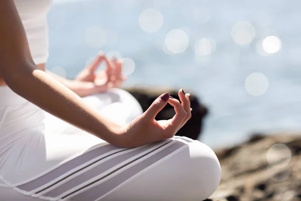 Giovane donna che fa yoga in spiaggia indossando vestiti bianchi — Foto Stock