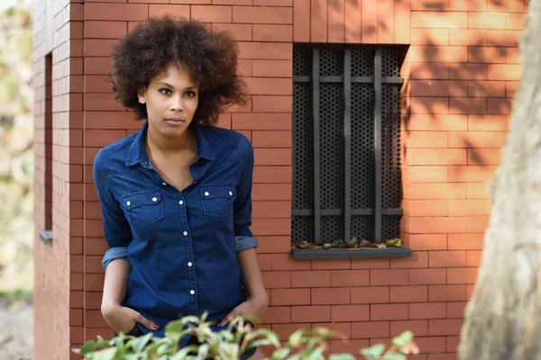 Joven mujer negra con peinado afro de pie en el fondo urbano —  Fotos de Stock