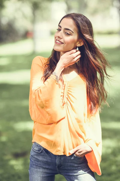 Mulher com cabelo em movimento vestindo roupas casuais no backgroun urbano — Fotografia de Stock