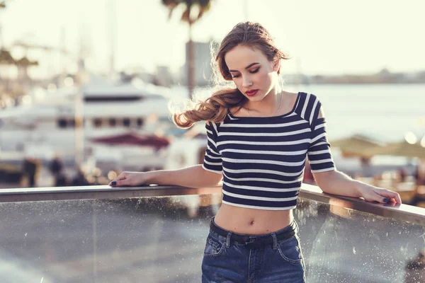 Mujer rubia, modelo de moda, sentada en el fondo urbano . — Foto de Stock