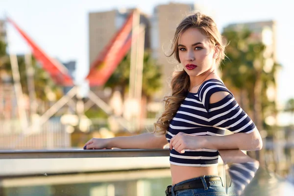 Blonde vrouw, model van de mode, zittend in de stedelijke achtergrond. — Stockfoto