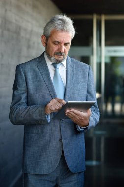 Modern ofis dışında tablet bilgisayar ile üst düzey iş adamı